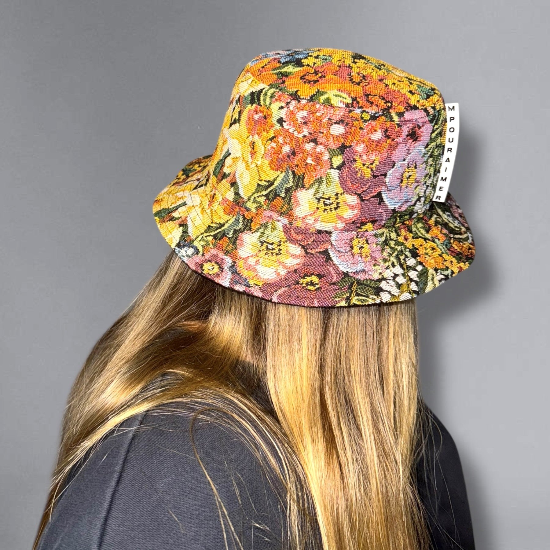 Chapeau style bucket hat, aussi appelé bob hat, en tissu jacquard fleuri à l’allure vintage, doublé de coton, avec œillets métalliques pour l’aération, fait à la main avec soin.